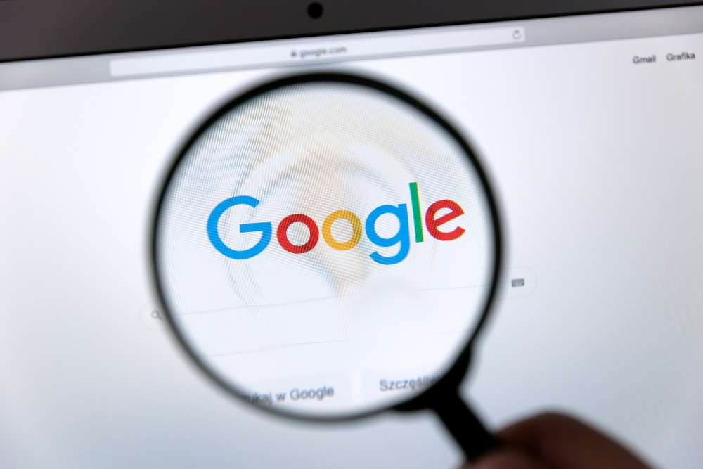 Lupa powiększająca logo Google wyświetlone na monitorze
